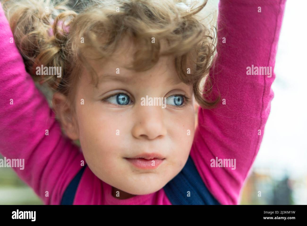 Porträt eines jungen Mädchens mit blondem lockiges Haar und großen blauen Augen; Toronto, Ontario, Kanada Stockfoto