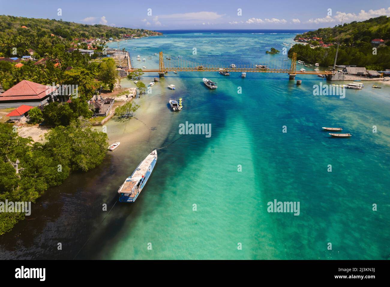 Bucht mit Booten entlang einer tropischen Küste, Komodo Nationalpark; East Nusa Tenggara, Indonesien Stockfoto