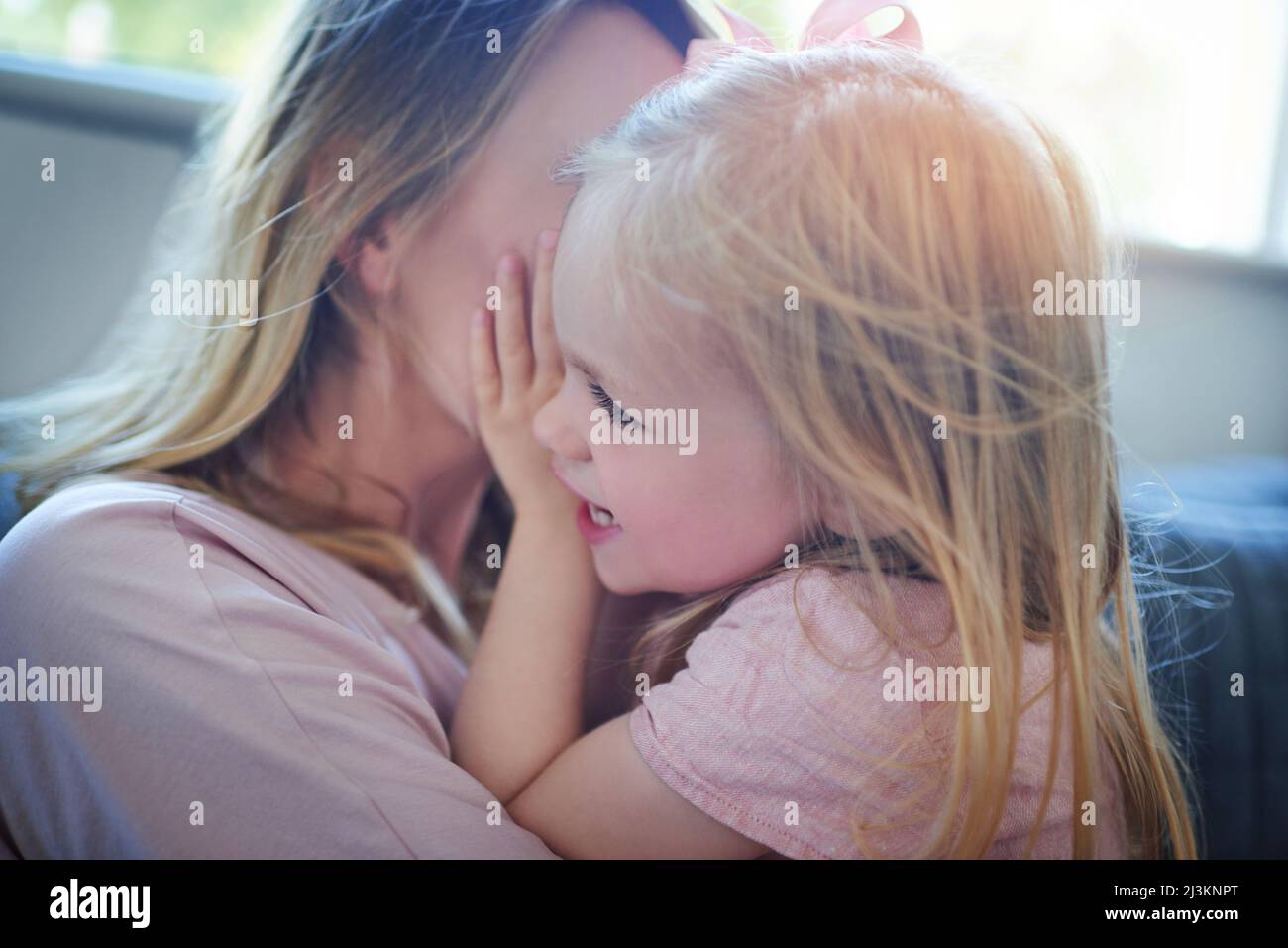 Glück ist ein Moment der Mama Tochter. Aufnahme eines entzückenden kleinen Mädchens, das sich zu Hause mit ihrer Mutter verklebt. Stockfoto