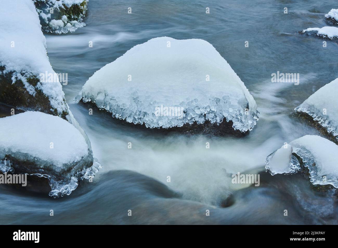 Eis- und Schneedetails in einem Bach, der durch einen verschneiten Wald im Naturreservat Hell im Bayerischen Wald fließt; Oberpfalz, Bayern, Deutschland Stockfoto