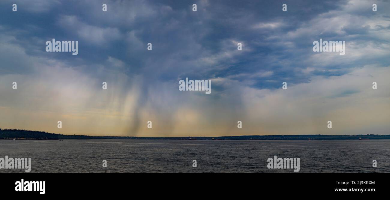 Regen, der von Sturmwolken über einer Küstenlinie und einem Ozean in der Ferne fällt, Sunshine Coast, BC, Kanada; British Columbia, Kanada Stockfoto