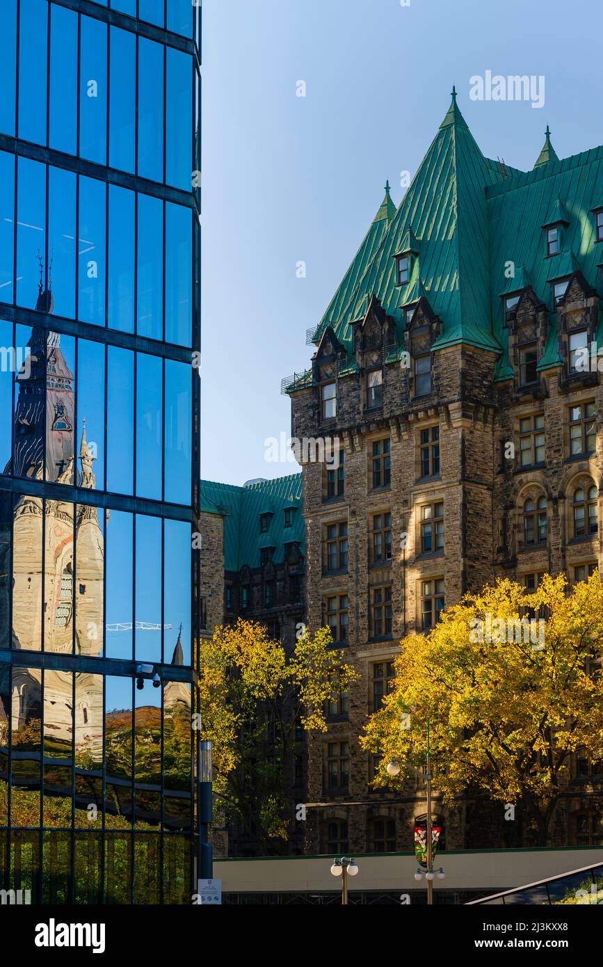 West Block der kanadischen Parlamentsgebäude und Canadian Parliament House spiegelt sich in der Glasfassade eines Gebäudes in der Hauptstadt der Nation... Stockfoto