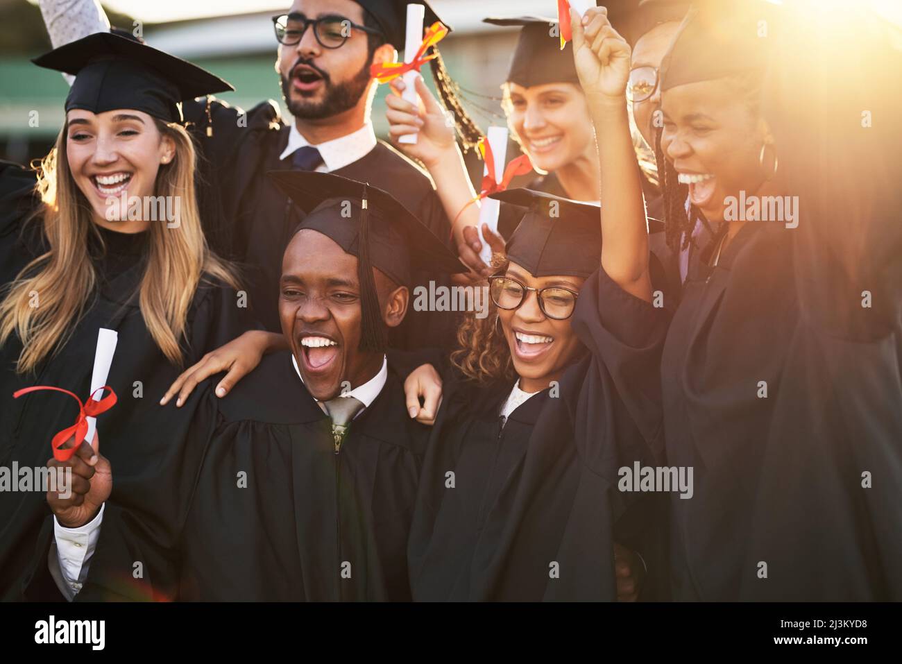 Unsere Eltern sind so stolz auf uns. Aufnahme einer Gruppe fröhlicher Studenten am Abschlusstag. Stockfoto