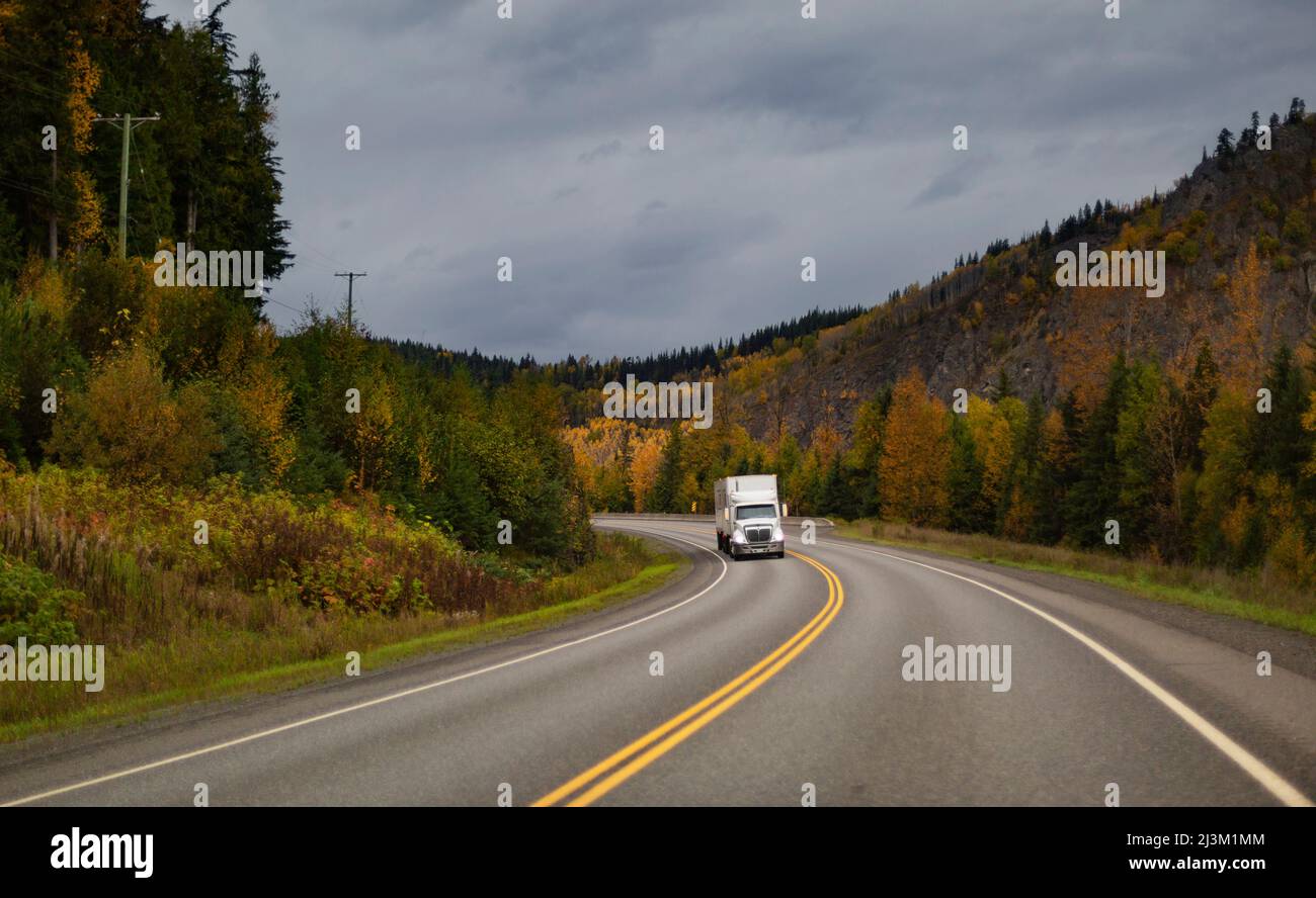 Transport-LKW auf dem Highway 16 mit Herbstbäumen am Straßenrand; British Columbia, Kanada Stockfoto