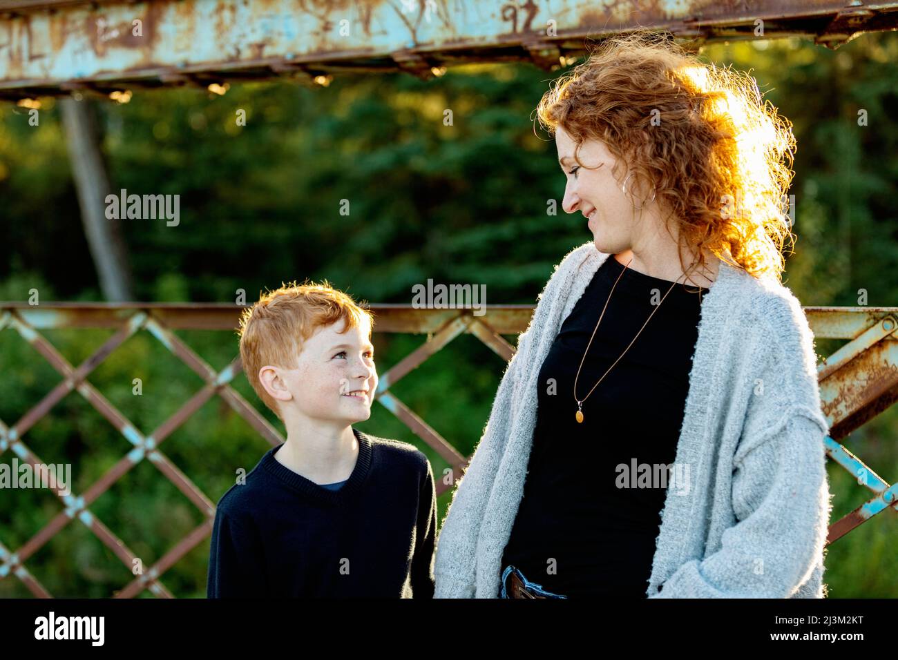 Mutter und Sohn, die sich in einem Park mit einem Lächeln anblicken; Edmonton, Alberta, Kanada Stockfoto