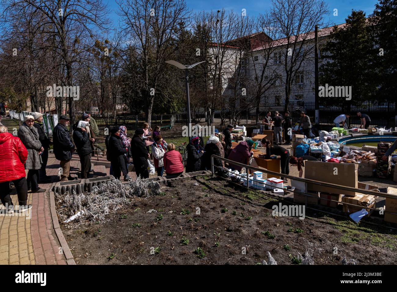 Nach der Befreiung der Stadt von den russischen Eindringlingen, Bucha, Region Kiew, Nordukraine, im April 7, stehen Menschen Schlange, um humanitäre Hilfe zu erhalten. 2022. Nach Angaben des Bürgermeisters wurden nach einem Massenmord in Bucha mehr als 300 Einwohner der Stadt tot aufgefunden. Die Ukraine hat den IStGH gebeten, zu untersuchen, was in der Stadt im Rahmen ihrer laufenden Untersuchung der Invasion geschehen ist, um festzustellen, ob eine Reihe von russischen Kriegsverbrechen begangen wurden.[die russischen Behörden haben die Verantwortung verweigert und behauptet, dass die Ukraine Aufnahmen des Ereignisses gefälscht oder inszeniert hat Tötung selbst ein Stockfoto