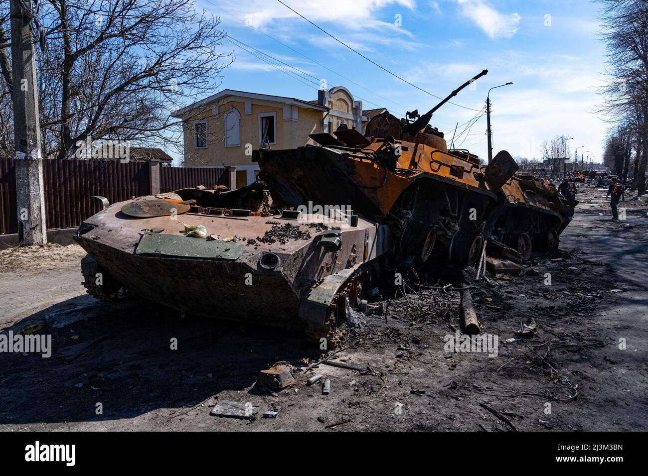 Nach der Befreiung der Stadt von den russischen Eindringlingen, Bucha, Region Kiew, Nordukraine, April 7, sind zerstörte Militärfahrzeuge in der Nähe eines Zauns mit dem Wort „Volk“ zu sehen. 2022. Nach Angaben des Bürgermeisters wurden nach einem Massenmord in Bucha mehr als 300 Einwohner der Stadt tot aufgefunden. Die Ukraine hat den Internationalen Strafgerichtshof gebeten, im Rahmen der laufenden Untersuchung der Invasion zu untersuchen, was in der Stadt geschehen ist, um festzustellen, ob eine Reihe russischer Kriegsverbrechen begangen wurden.[die russischen Behörden haben die Verantwortung verweigert und behauptet, dass die Ukraine Aufnahmen von Th gefälscht habe Stockfoto
