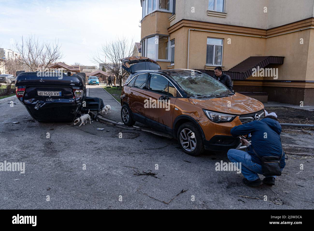 Männer untersuchen zerstörte Autos nach der Befreiung der Stadt von russischen Eindringlingen, Bucha, Region Kiew, Nordukraine, April 7, 2022. Nach Angaben des Bürgermeisters wurden nach einem Massenmord in Bucha mehr als 300 Einwohner der Stadt tot aufgefunden. Die Ukraine hat den IStGH gebeten, zu untersuchen, was in der Stadt im Rahmen ihrer laufenden Untersuchung der Invasion geschehen ist, um festzustellen, ob eine Reihe von russischen Kriegsverbrechen begangen wurden.[die russischen Behörden haben die Verantwortung verweigert und behauptet, dass die Ukraine Aufnahmen des Ereignisses gefälscht oder inszeniert hat Tötung selbst als falsche Flagge Stockfoto