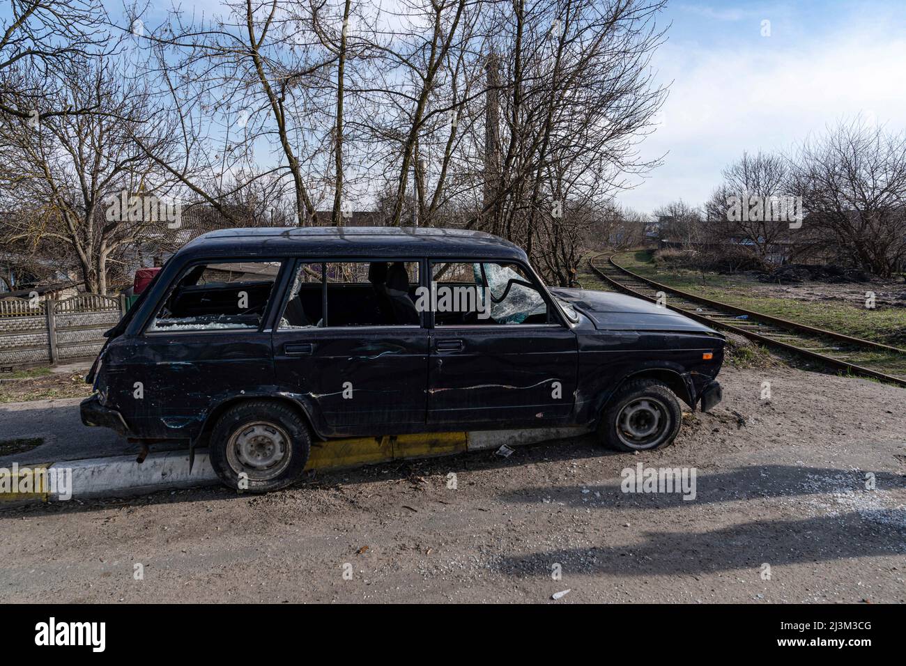 Nach der Befreiung der Stadt von russischen Eindringlingen, Bucha, Region Kiew, Nordukraine, April 7, wird ein beschädigtes Auto auf einer Straße gesehen. 2022. Nach Angaben des Bürgermeisters wurden nach einem Massenmord in Bucha mehr als 300 Einwohner der Stadt tot aufgefunden. Die Ukraine hat den IStGH gebeten, zu untersuchen, was in der Stadt im Rahmen ihrer laufenden Untersuchung der Invasion geschehen ist, um festzustellen, ob eine Reihe von russischen Kriegsverbrechen begangen wurden.[die russischen Behörden haben die Verantwortung verweigert und behauptet, dass die Ukraine Aufnahmen des Ereignisses gefälscht oder inszeniert hat Tötung selbst als fal Stockfoto