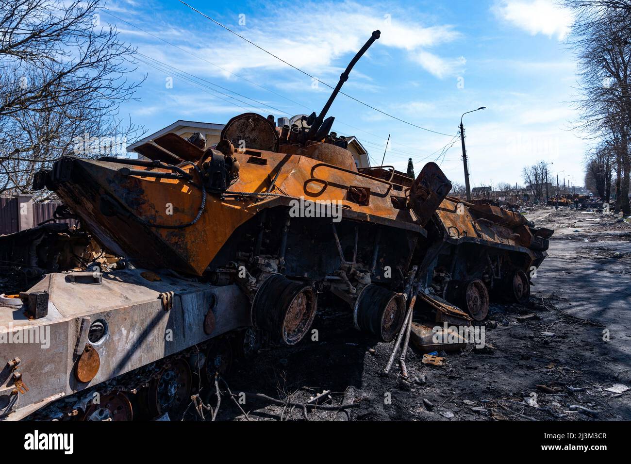 Nach der Befreiung der Stadt von den russischen Eindringlingen, Bucha, Region Kiew, Nordukraine, April 7, sind zerstörte Militärfahrzeuge in der Nähe eines Zauns mit dem Wort „Volk“ zu sehen. 2022. Nach Angaben des Bürgermeisters wurden nach einem Massenmord in Bucha mehr als 300 Einwohner der Stadt tot aufgefunden. Die Ukraine hat den Internationalen Strafgerichtshof gebeten, im Rahmen der laufenden Untersuchung der Invasion zu untersuchen, was in der Stadt geschehen ist, um festzustellen, ob eine Reihe russischer Kriegsverbrechen begangen wurden.[die russischen Behörden haben die Verantwortung verweigert und behauptet, dass die Ukraine Aufnahmen von Th gefälscht habe Stockfoto