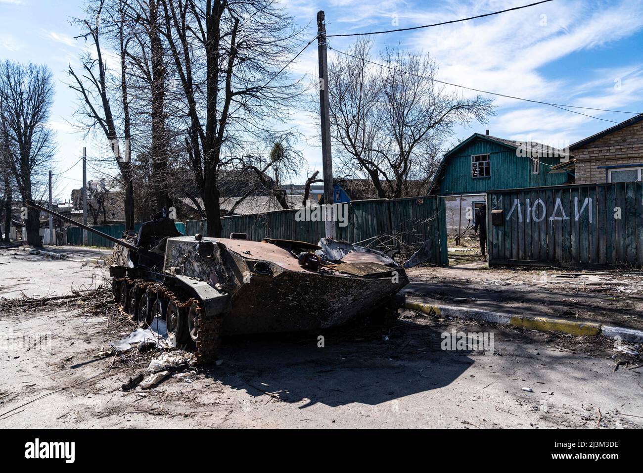 Nach der Befreiung der Stadt von den russischen Eindringlingen, Bucha, Region Kiew, Nordukraine, 7. April, ist in der Nähe eines Zauns mit dem Wort „Volk“ ein zerstörtes Militärfahrzeug zu sehen. 2022. Nach Angaben des Bürgermeisters wurden nach einem Massenmord in Bucha mehr als 300 Einwohner der Stadt tot aufgefunden. Die Ukraine hat den Internationalen Strafgerichtshof gebeten, im Rahmen der laufenden Untersuchung der Invasion zu untersuchen, was in der Stadt geschehen ist, um festzustellen, ob eine Reihe russischer Kriegsverbrechen begangen wurden.[die russischen Behörden haben die Verantwortung verweigert und behauptet, dass die Ukraine Aufnahmen von Th gefälscht habe Stockfoto