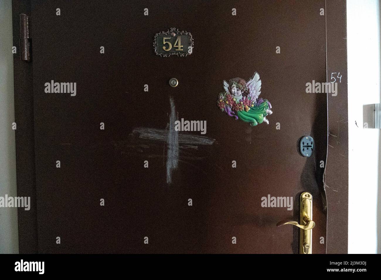 Nach der Befreiung der Stadt von den russischen Eindringlingen, Bucha, Region Kiew, Nordukraine, am 7. April, wird ein Kreuz an der Tür einer Wohnung angekreidet. 2022. Nach Angaben des Bürgermeisters wurden nach einem Massenmord in Bucha mehr als 300 Einwohner der Stadt tot aufgefunden. Die Ukraine hat den IStGH gebeten, zu untersuchen, was in der Stadt im Rahmen ihrer laufenden Untersuchung der Invasion geschehen ist, um festzustellen, ob eine Reihe von russischen Kriegsverbrechen begangen wurden.[die russischen Behörden haben die Verantwortung verweigert und behauptet, dass die Ukraine Aufnahmen des Ereignisses gefälscht oder inszeniert hat Es wird getötet Stockfoto