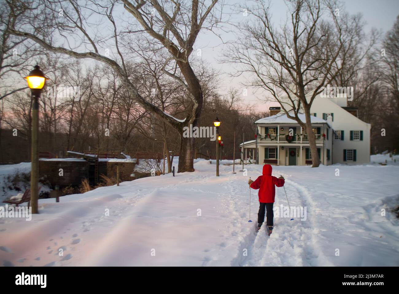 Ein 9-jähriger Junge fährt Langlaufskier zur Great Falls Tavern, Great Falls, Kichapeake und zum Ohio National Historic Park, Maryland. Stockfoto