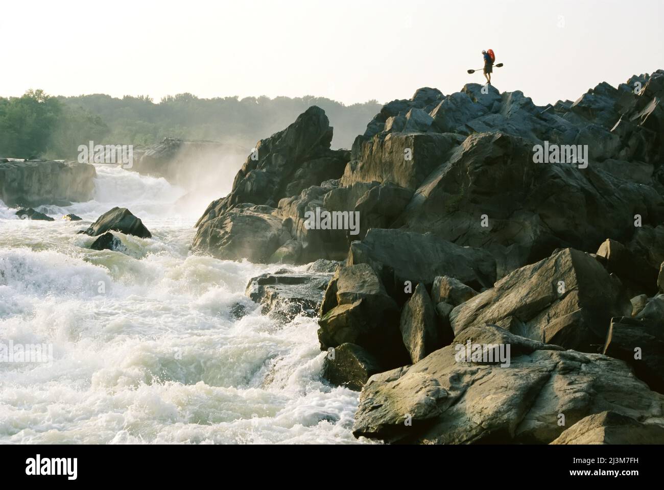 Kayaker trägt Boot auf den Felsen der Great Falls auf dem Potomac River.; POTOMAC RIVER. Stockfoto