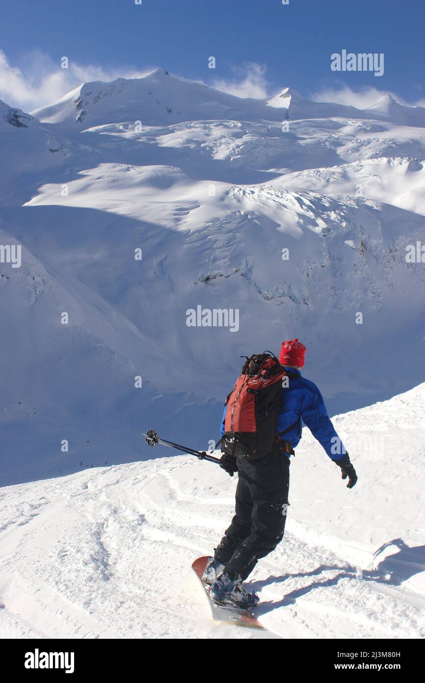 Ein Back Country Snowboarder senkt ein Schneefeld in Richtung eines Gletschers.; Selkirk Mountains, British Columbia, Kanada. Stockfoto