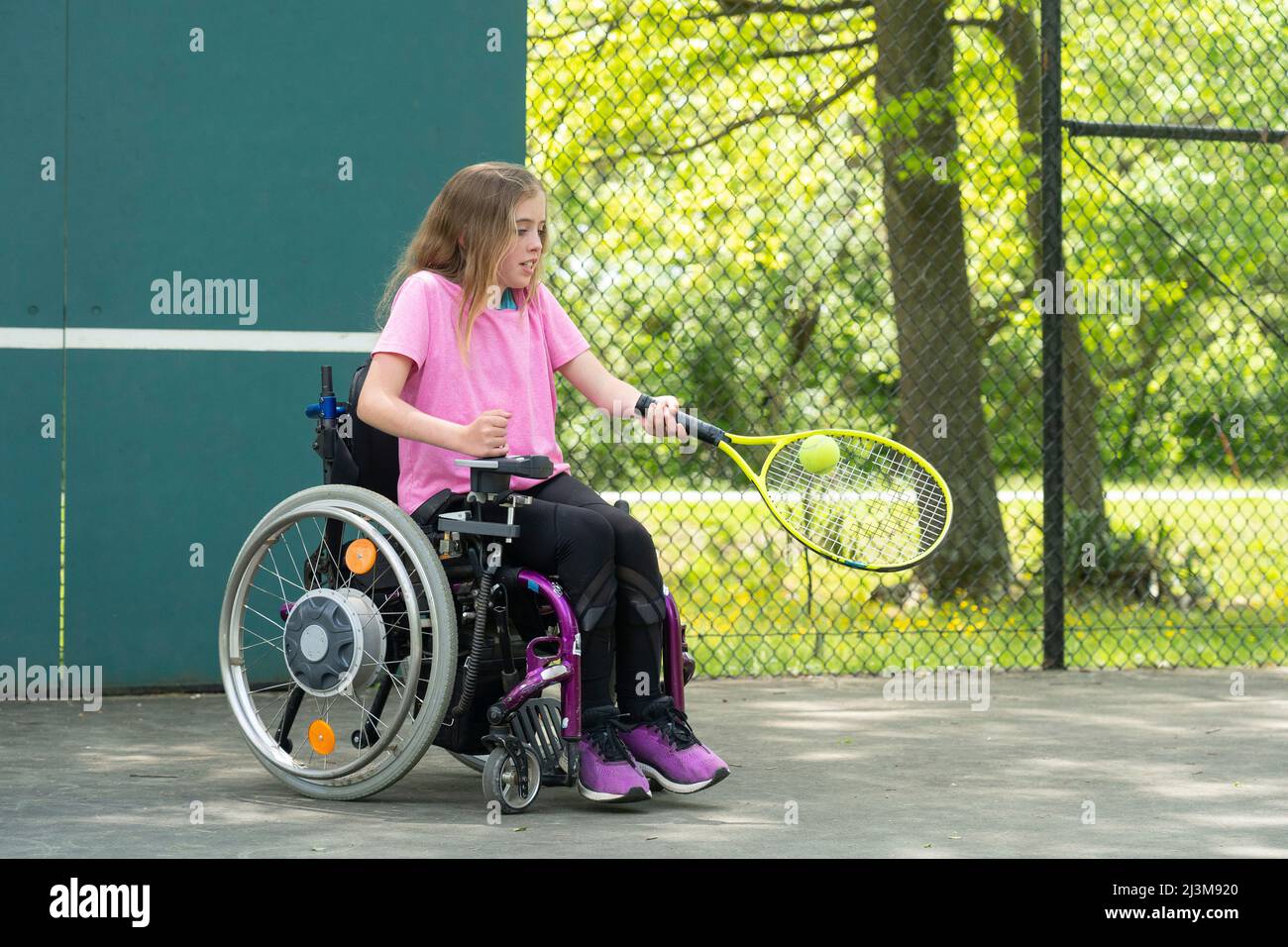 Mädchen mit Ullrich Congenital Muscular Dystrophy spielt Tennis in ihrem Rollstuhl; Cabin John, Maryland, Vereinigte Staaten von Amerika Stockfoto