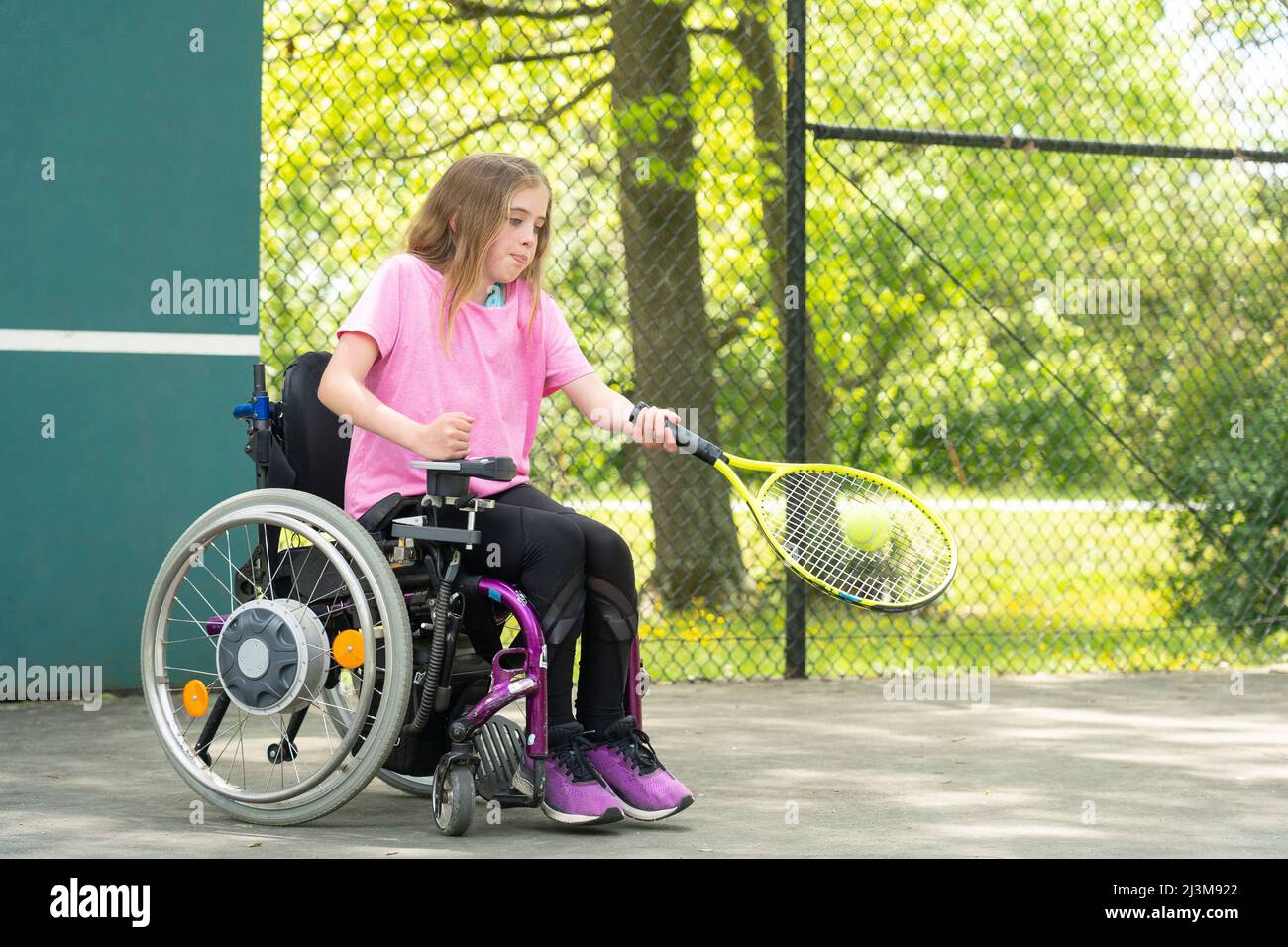 Mädchen mit Ullrich Congenital Muscular Dystrophy spielt Tennis in ihrem Rollstuhl; Cabin John, Maryland, Vereinigte Staaten von Amerika Stockfoto