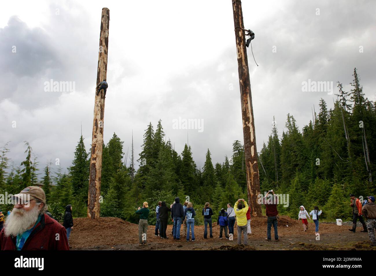 Holzfäller kämpfen während einer Holzfällershow, die Einheimische anzieht, ihre Fähigkeiten auf der Prince of Wales Island im Südosten Alaskas zu zeigen, um einen 65-Fuß-Stock zu besteigen. Stockfoto
