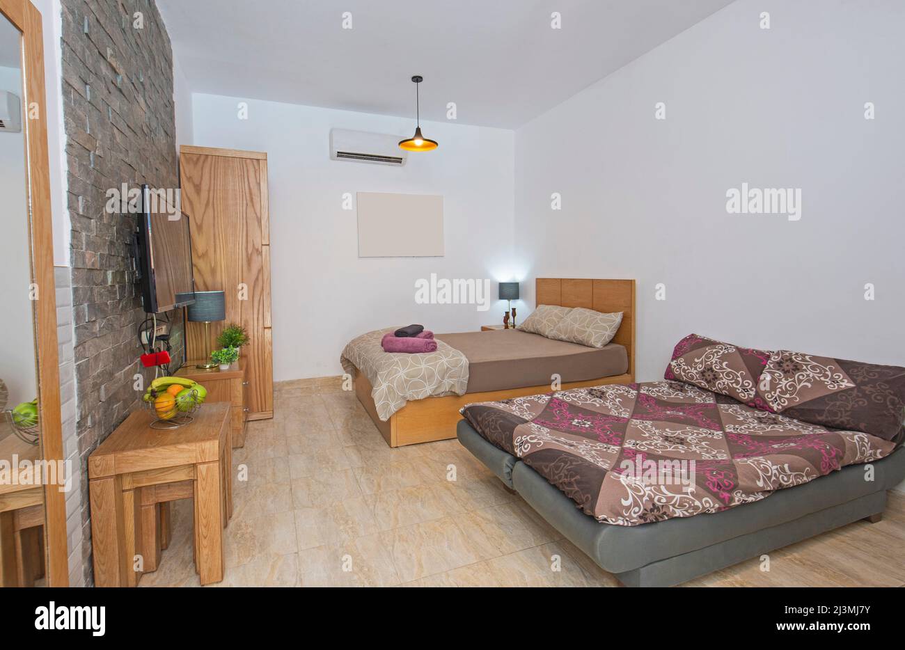 Inneneinrichtung mit modernem Schlafbereich im offenen Luxus-Studio-Apartment-Showroom mit Schlafsofa Stockfoto