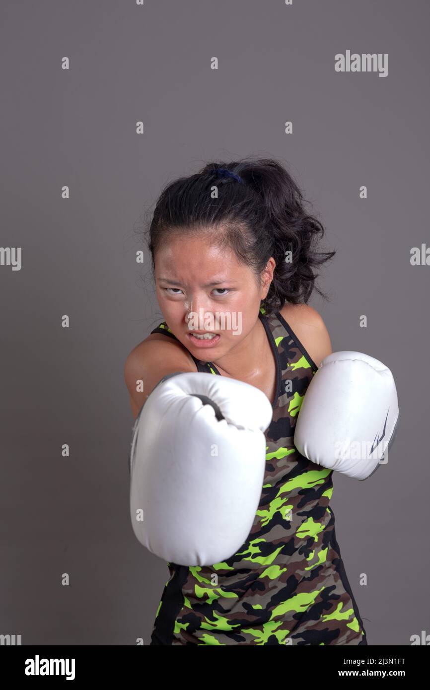 Foto einer schönen jungen asiatischen Frau, die Boxhandschuhe trägt Stockfoto