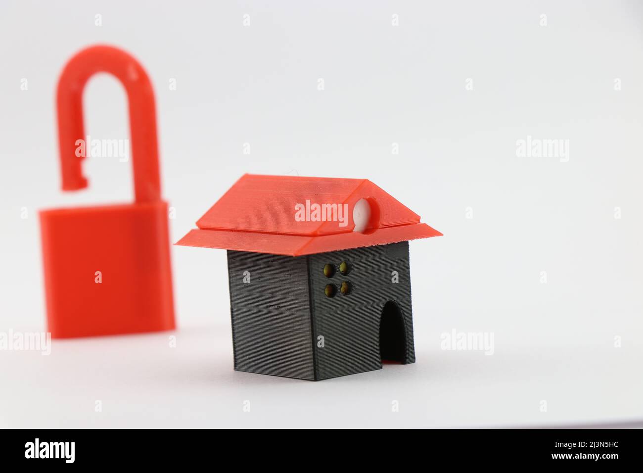 3D gedrucktes Miniaturhaus mit offenem Vorhängeschloss auf einem Hintergrund, das das Konzept eines hypothekenfreien Hauses zeigt, Immobilienfinanzierungskonzept Stockfoto