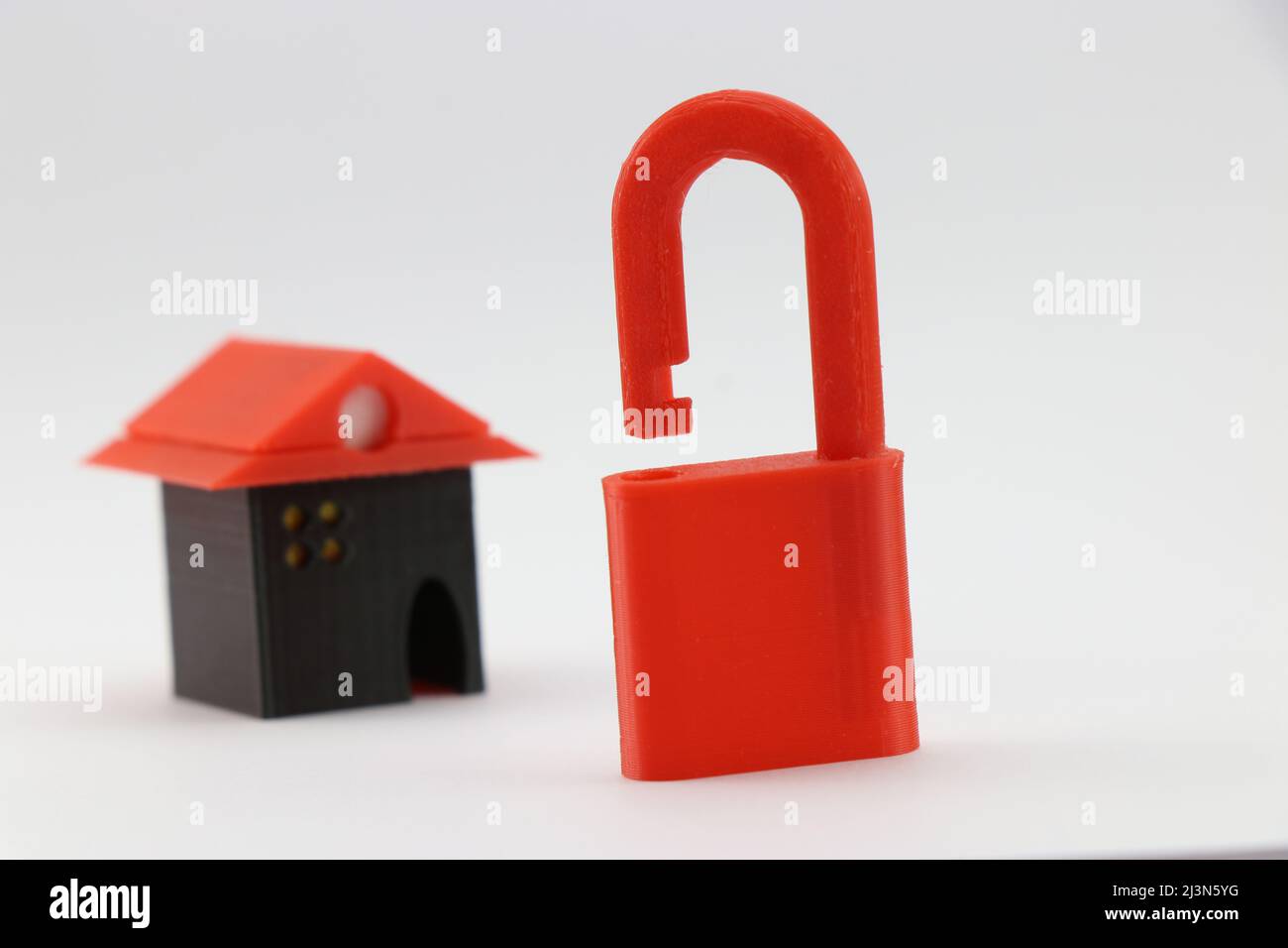 Vorhängeschloss und kleines Zuhause sind 3D gedruckte Objekte, die das Konzept der Sicherheit zu Hause, Mortage und Finanzen Konzept zeigen Stockfoto
