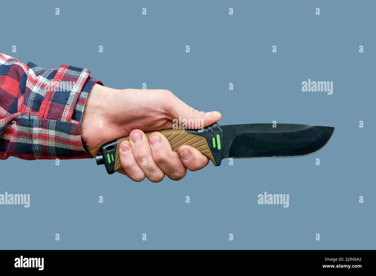 Eine Männerhand hält ein großes taktisches Messer mit einem Kunststoffgriff auf grauem Hintergrund Stockfoto