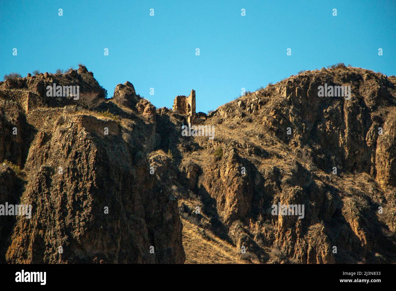 Gebirge in Georgien. Berglandschaft im Sommer. Blauer Himmel und sonnendurchflutete Felsen. Blick auf die Höhlenstadt. Stockfoto