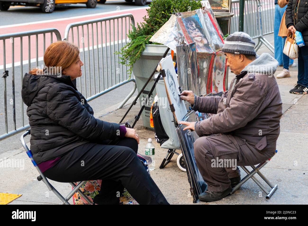 New York City, New York, USA - 21. November 2021: Eine Künstlerin, die auf einem Bürgersteig vor dem Central Park auf einem Stuhl sitzt, einen Portrail einer Frau draufpirstert Stockfoto