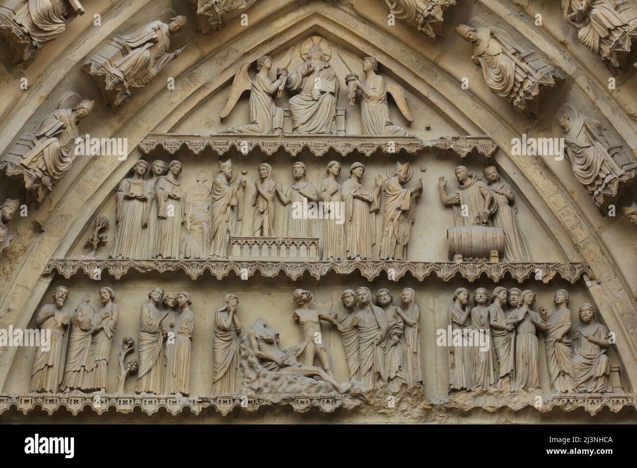 Wunder des heiligen Remigius von Reims (obere Ebene) und die biblische Geschichte von Hiob (untere Ebene), dargestellt im Tympanon des zentralen Portals der Nordfassade der Kathedrale von Reims (Cathédrale Notre-Dame de Reims) in Reims, Frankreich. Stockfoto