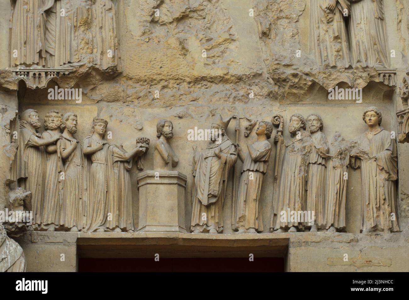 Taufe von König Clovis I. durch den heiligen Remigius von Reims, dargestellt im Tympanon des zentralen Portals der Nordfassade der Kathedrale von Reims (Cathédrale Notre-Dame de Reims) in Reims, Frankreich. Stockfoto