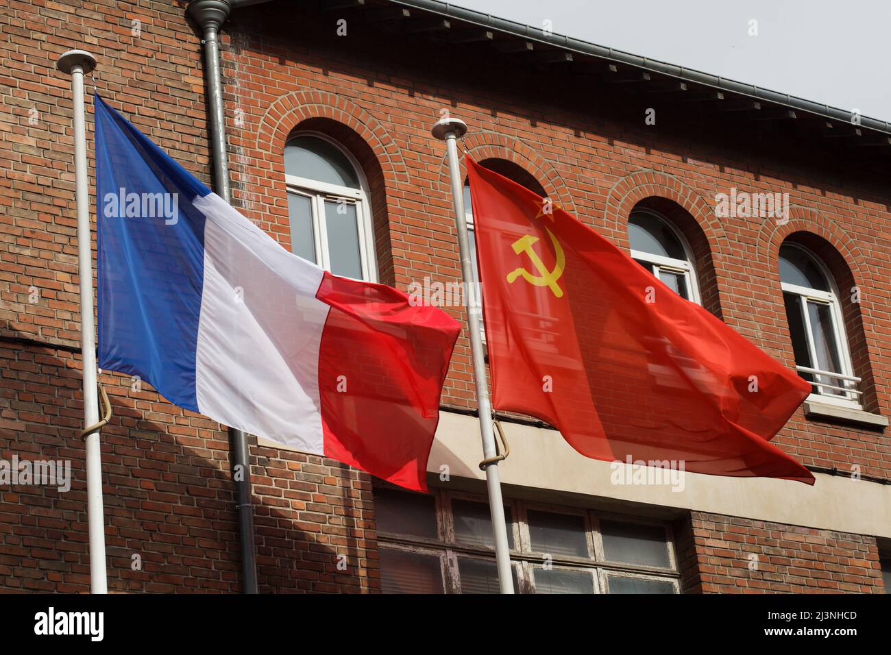 Am Eingang des Museums der Kapitulation (Musée de la Redadition) in Reims, Frankreich, winken die Nationalflaggen Frankreichs und der Sowjetunion. Das erste deutsche Kapitulationsinstrument, das den Zweiten Weltkrieg in Europa beendete, wurde in diesem Gebäude am 7. Mai 1945 um 02:41 Uhr mitteleuropäischer Zeit (MEZ) unterzeichnet. Stockfoto