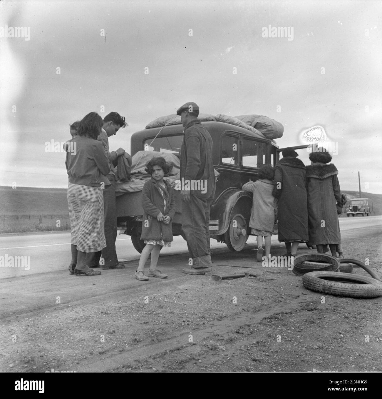 Migranten, Familie von Mexikanern, mit Reifenpanne unterwegs. Auf der Suche nach Arbeit in den Erbsen. Kalifornien. Stockfoto