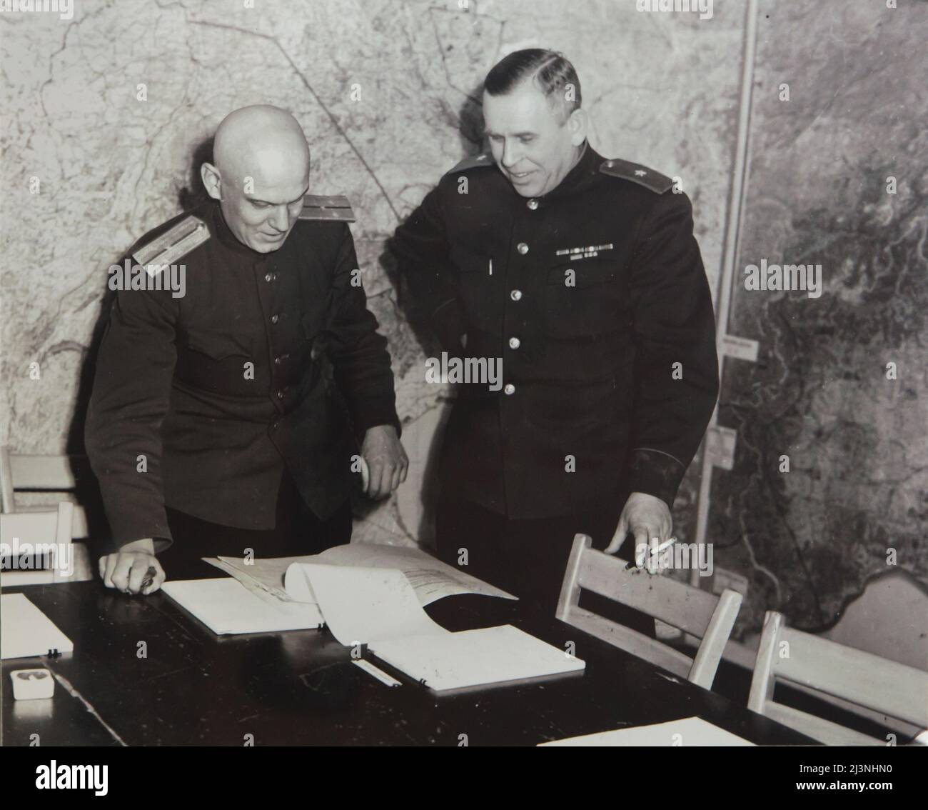Der sowjetische General Ivan Susloparov (auch als Ivan Sousloparov geschrieben) und sein Dolmetscher Ivan Cherniaev (links) im Kartenraum, auch bekannt als der Kriegsraum des Obersten Hauptquartiers der alliierten Expeditionstruppe (SHAEF) im Museum der Kapitulation (Musée de la Reddition) in Reims, Frankreich, Am 6. Mai 1945. Das erste deutsche Kapitulationsinstrument, das den Zweiten Weltkrieg in Europa beendete, wurde am 7. Mai 1945 um 02:41 Uhr mitteleuropäischer Zeit (MEZ) auf diesem Tisch in diesem Raum unterzeichnet. Der historische Raum dient heute als Teil des Museums der Kapitulation (Musée de la Reddition). Das Schwarze und das Whi Stockfoto