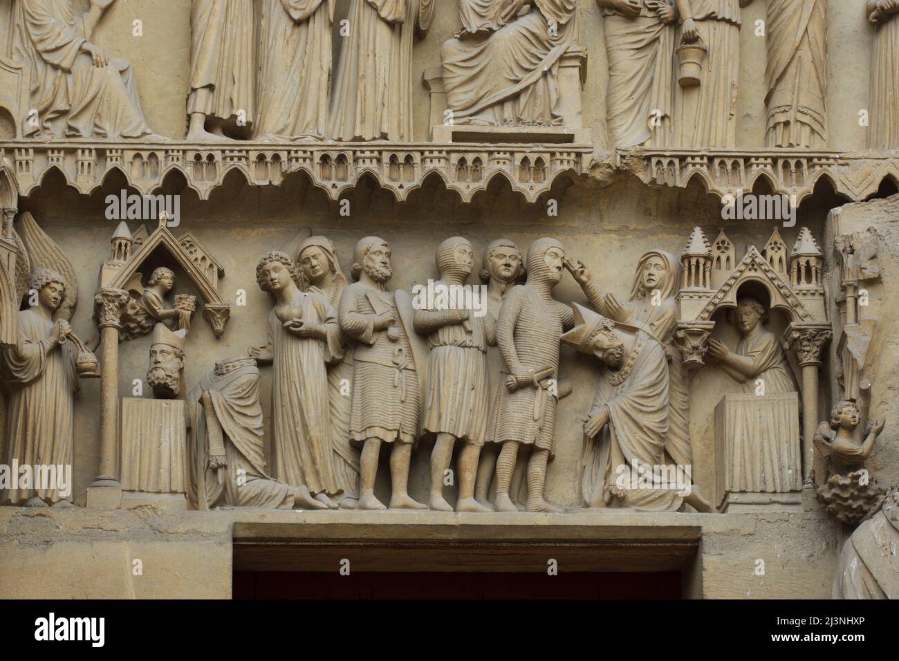 Enthauptung des Heiligen Nicasius von Reims, dargestellt im Tympanon des zentralen Portals der Nordfassade der Kathedrale von Reims (Cathédrale Notre-Dame de Reims) in Reims, Frankreich. Stockfoto