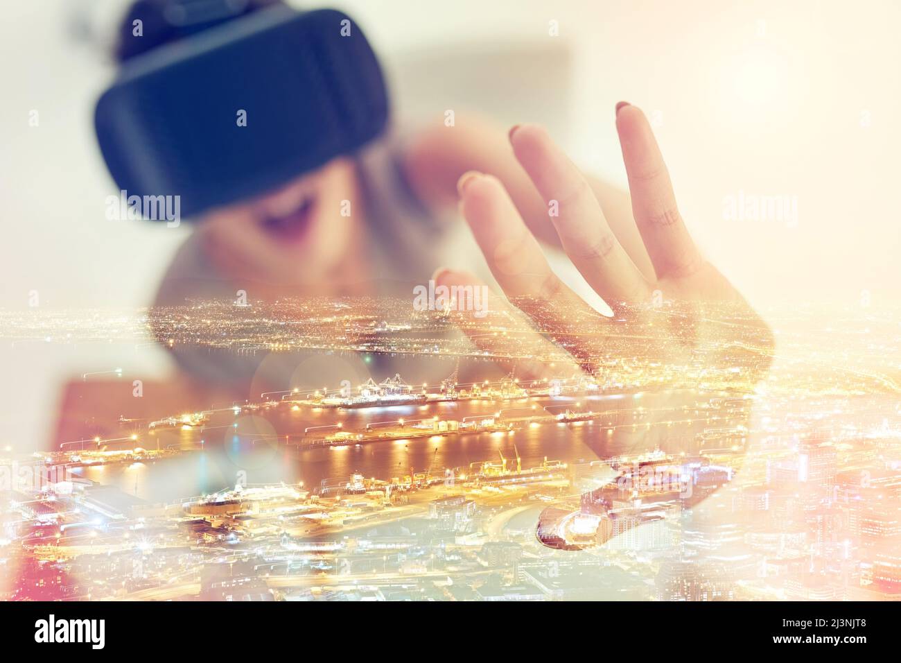 Die Zukunft prognostiziert und neu definiert. Aufnahme einer jungen Geschäftsfrau mit einem VR-Headset, die über einem Stadtbild überlagert ist. Stockfoto
