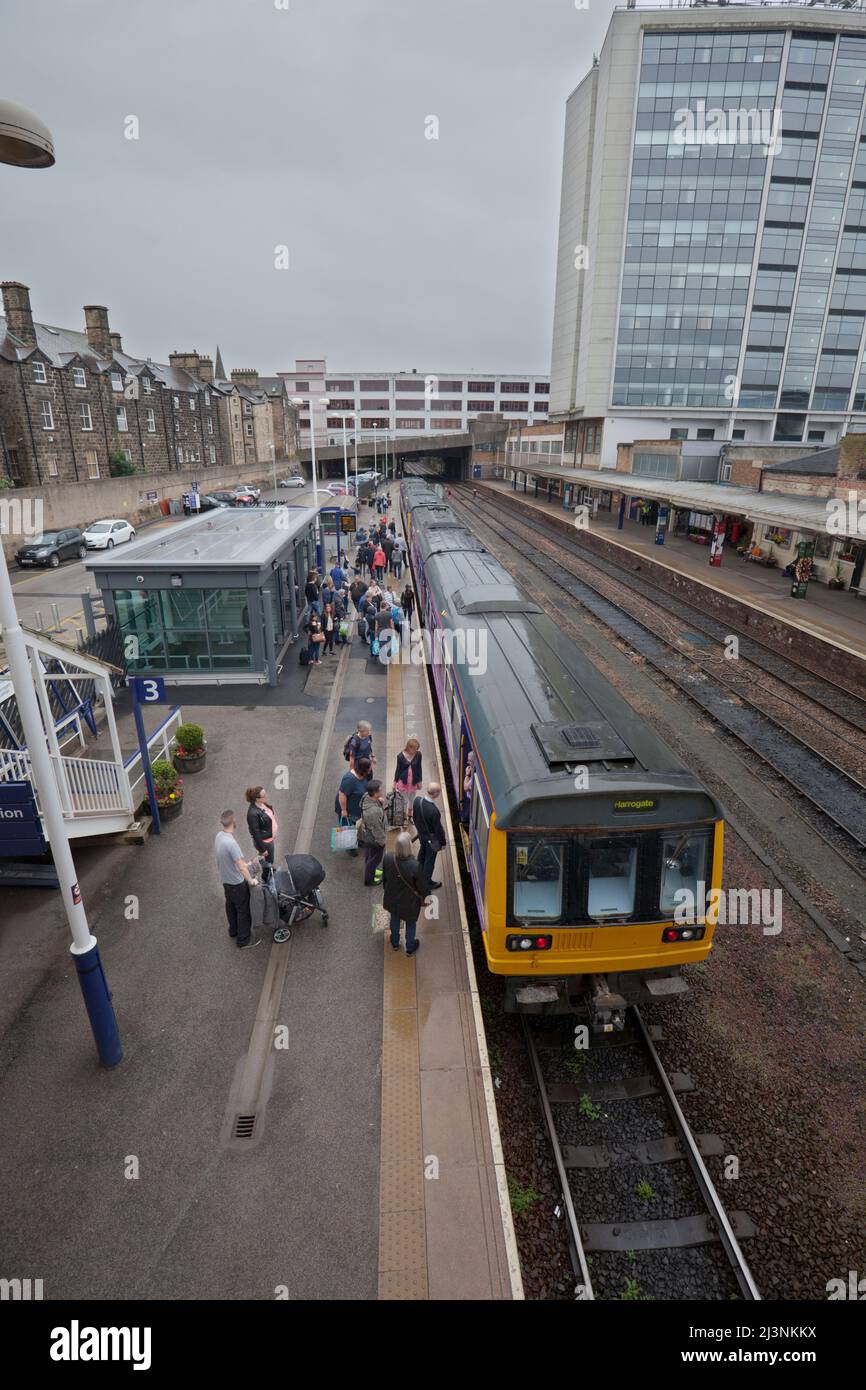 Passagiere, die am Bahnhof Harrogate ein- und aussteigen, fahren von einem Pacer-Zug der Northern Rail der Klasse 142. Stockfoto