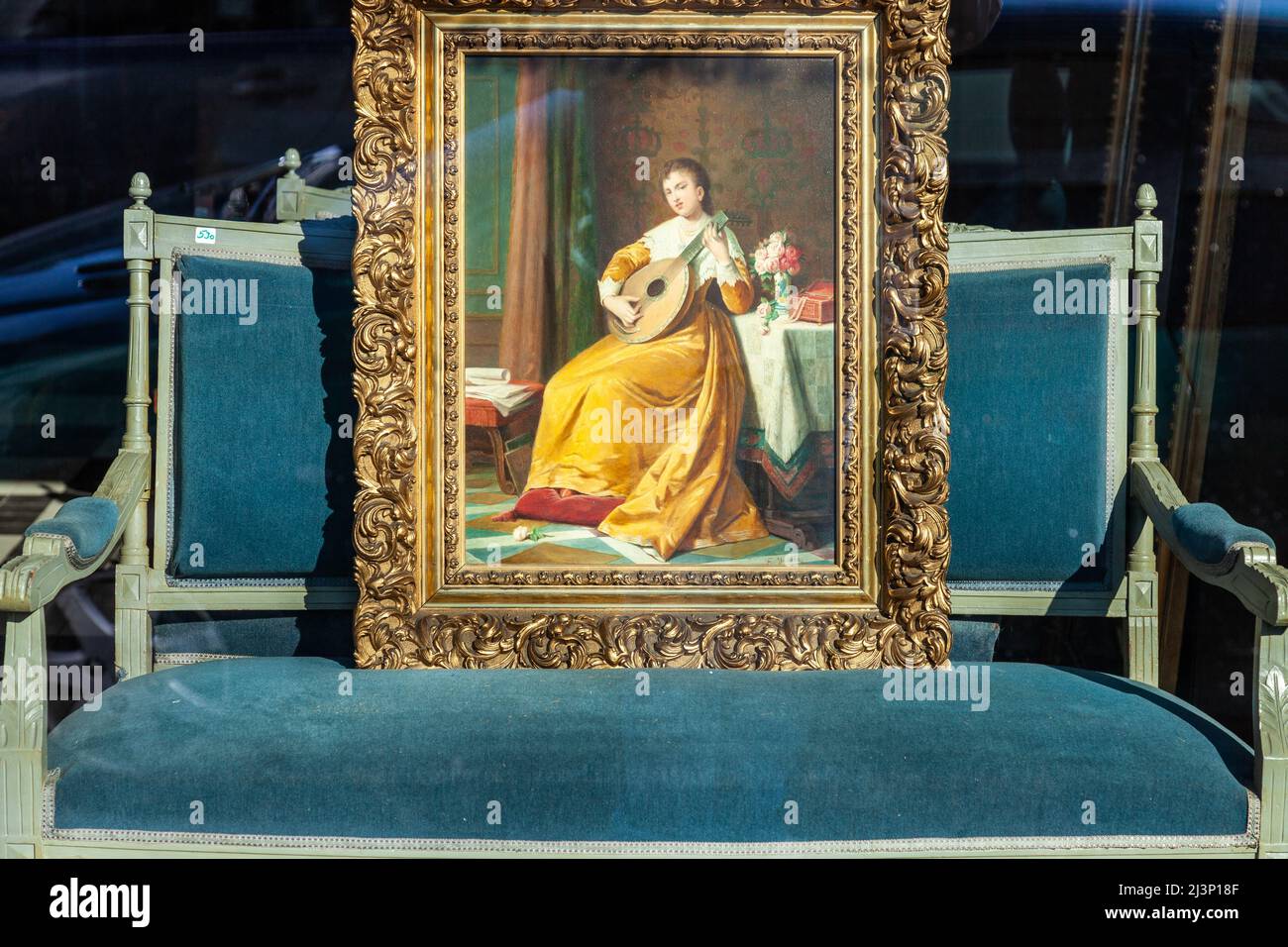 Gemälde im Stil der Renaissance, das auf einem alten Sofa im Fenster eines Antiquitätenhändlers in Brüssel platziert wurde Stockfoto