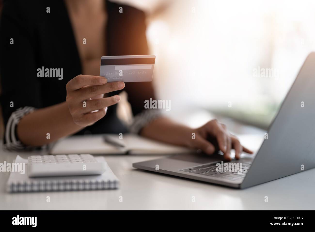 Junge Frau mit Kreditkarte und Laptop-Computer. Geschäftsfrau, die zu Hause arbeitet. Online-Shopping, E-Commerce, Internet-Banking, Ausgaben Stockfoto