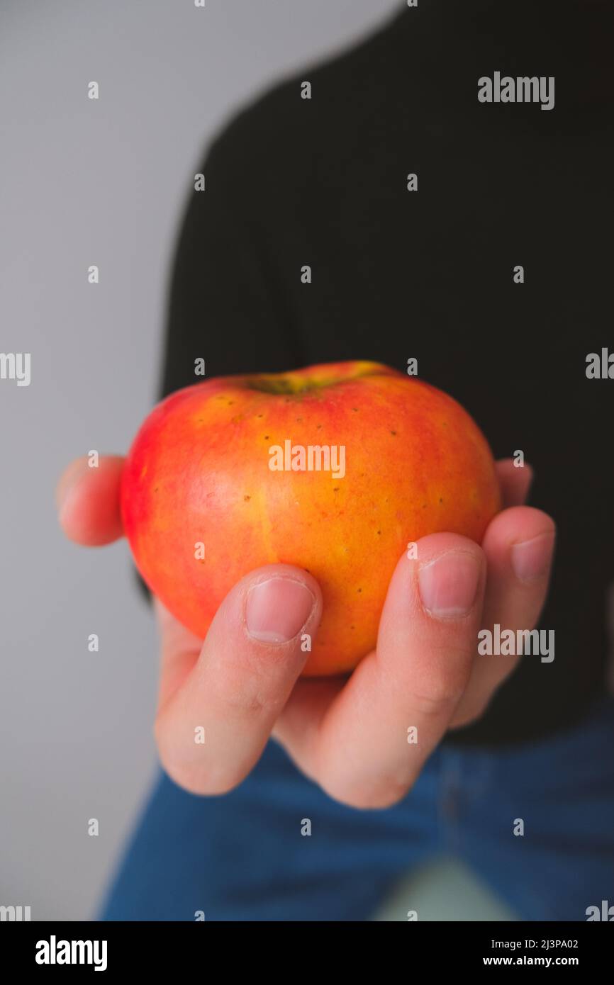 Die Hand des Mannes hält einen Apfel. Gesundes Lebensmittelkonzept Stockfoto