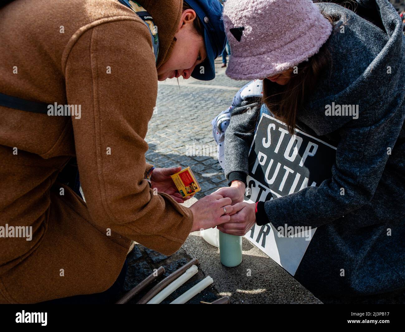 Amsterdam, Niederlande. 09. April 2022. Zwei Frauen werden auf der Straße Kerzen anzünden sehen. Nach den schrecklichen Ereignissen, die sich diese Woche in Bucha (Ukraine) ereigneten, organisierte die russische Gemeinschaft in den Niederlanden eine Mahnwache, um an die Opfer der Gräueltaten der Russischen Föderation zu erinnern. Am Dam-Platz versammelten sich Menschen in schwarzen Kleidern und mit Plakaten mit den Namen der ukrainischen Städte, die von der russischen Armee angegriffen wurden. Die Veranstaltung war eine stille Traueraktion ohne Ankündigungen oder Reden. Kredit: SOPA Images Limited/Alamy Live Nachrichten Stockfoto