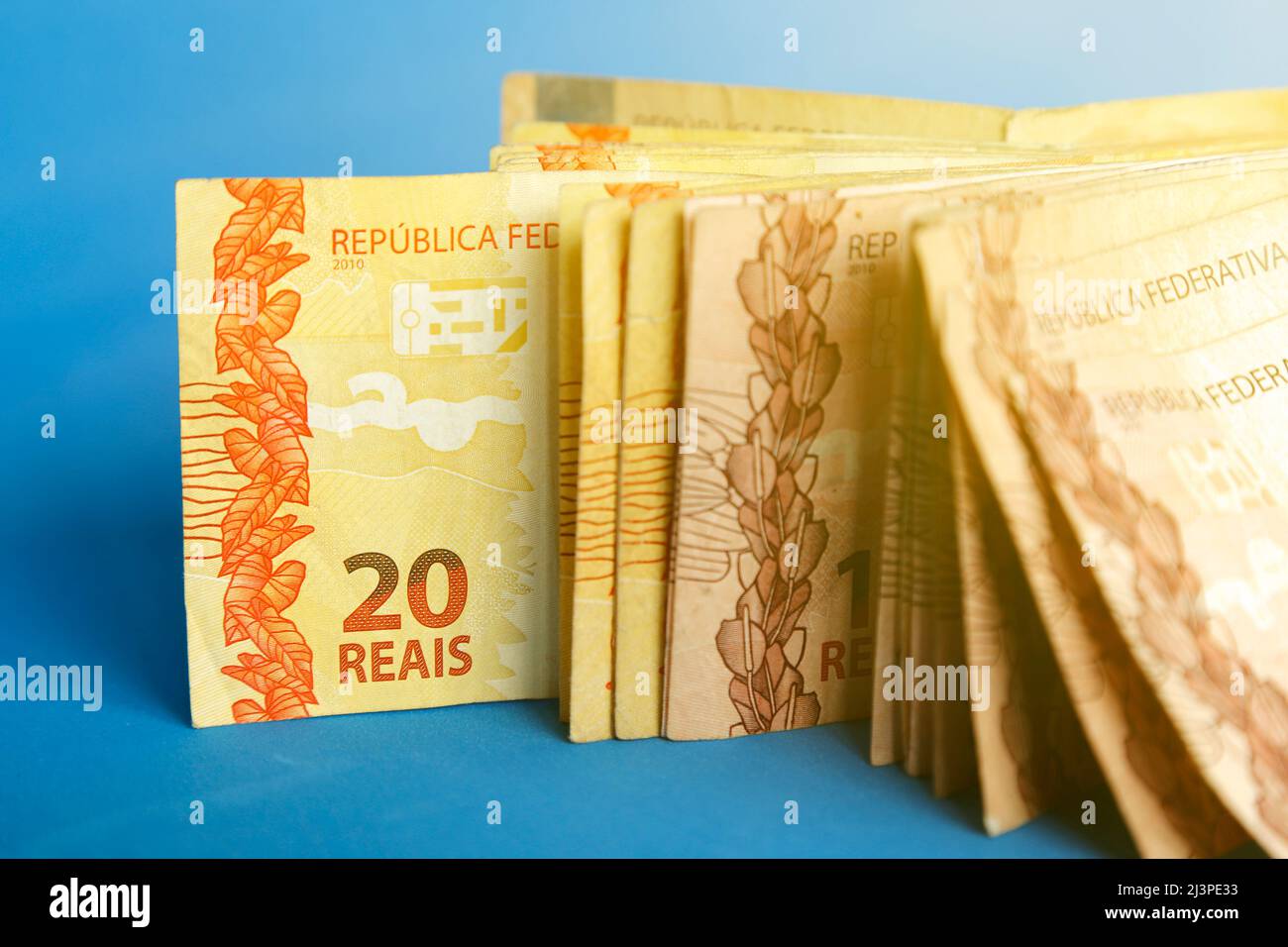 Mehrere echte brasilianische Banknoten standen auf einem blauen Tisch - der Schwerpunkt lag auf der zwanzig Banknote Stockfoto