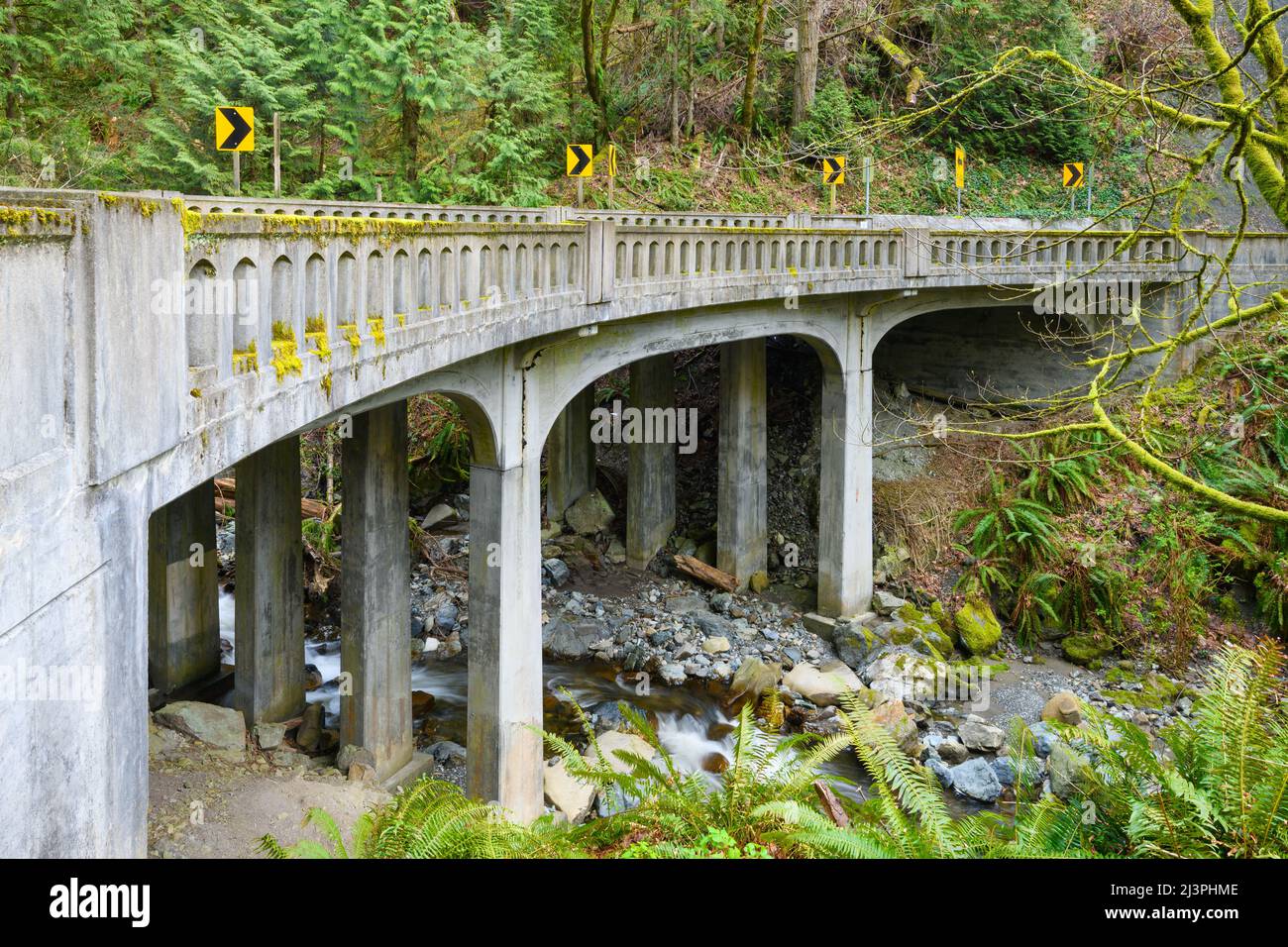 Landschaftlich schöner Chuckanut Drive, der über Oyster Creek auf einer Brücke mit einer scharfen Biegung im westlichen Bundesstaat Washington führt Stockfoto