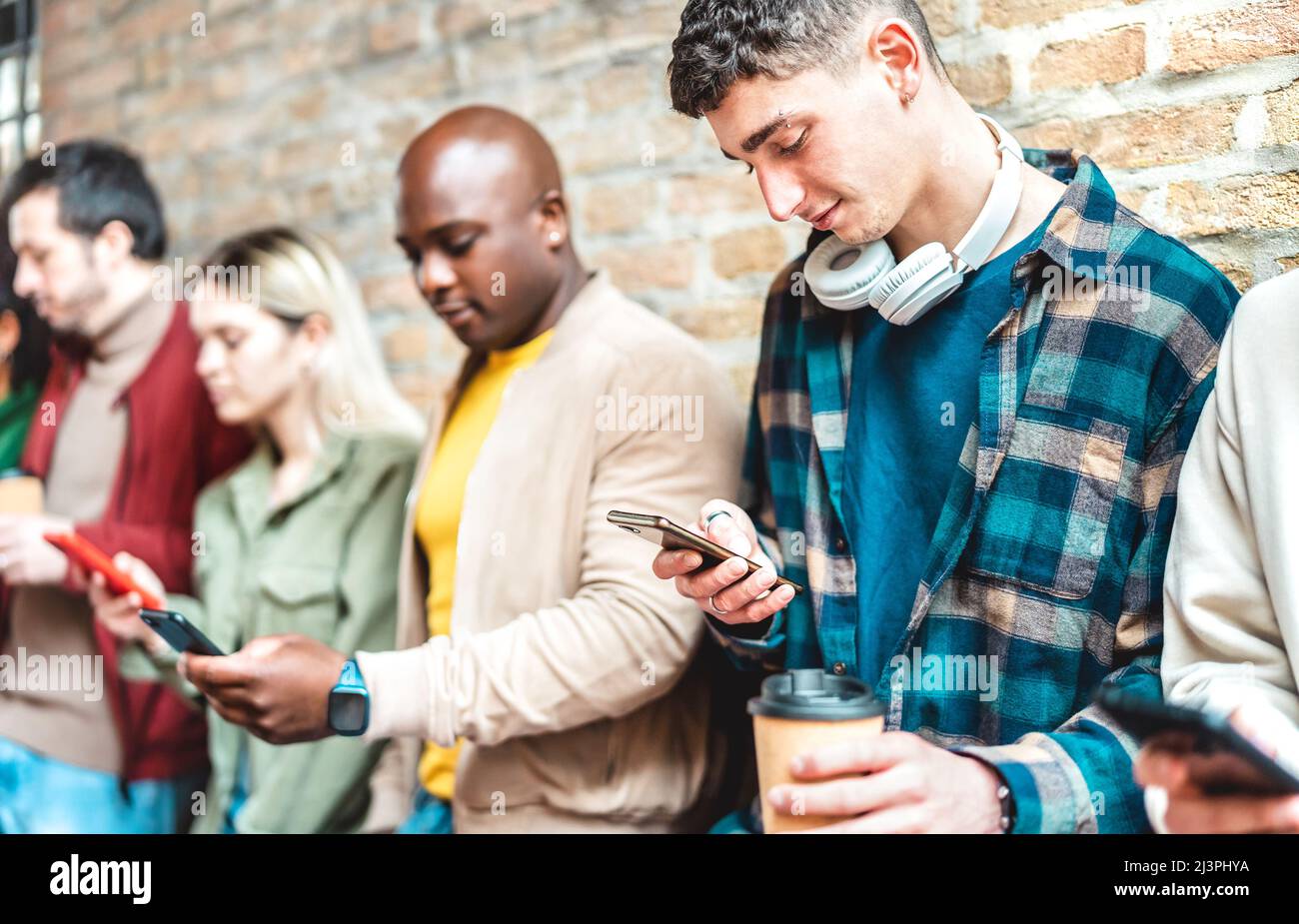 Multikulturelle Gruppe mit Smartphone und Kaffee in der Uni-College-Pause - Junge Freunde süchtig nach Handy - Tech-Lifestyle Stockfoto