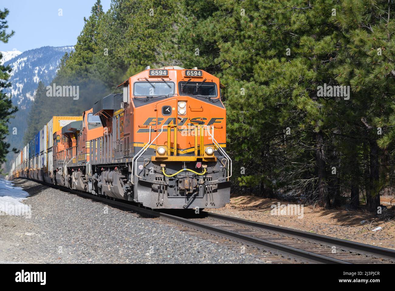 Leavenworth, WA, USA - 07. April 2022; der intermodale BNSF-Güterzug durchquert Anfang des Frühlings die Cascade Mountains im Bundesstaat Washington Stockfoto