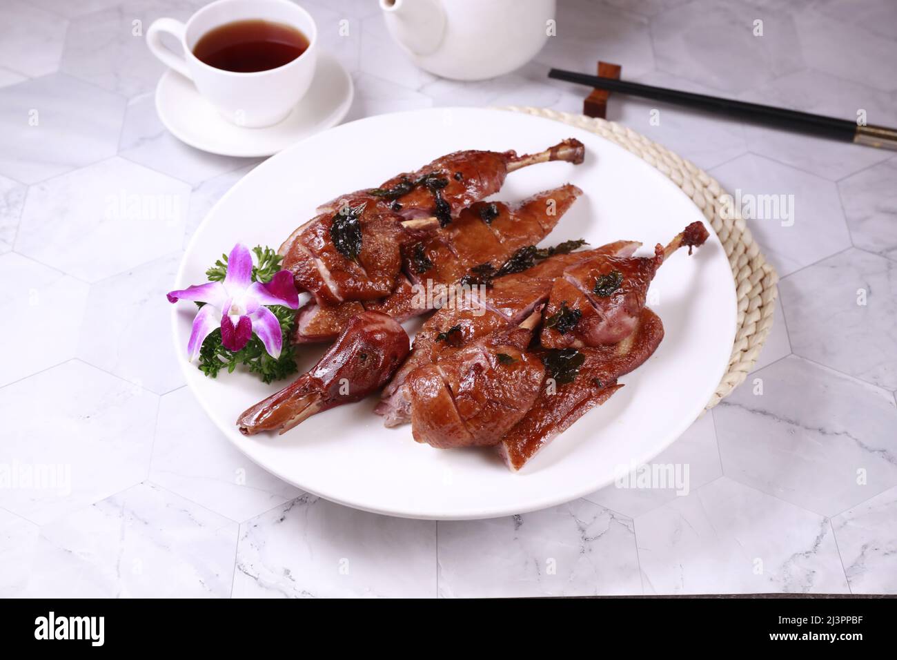 Gesalzene gebratene Ente in einem Gericht mit Blick auf den Tee auf grauem Hintergrund singapurs Essen Stockfoto