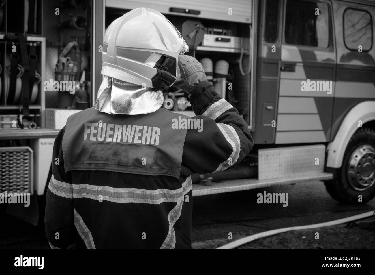 Ein Feuerwehrmann steht vor seinem Feuerwehrauto Stockfoto