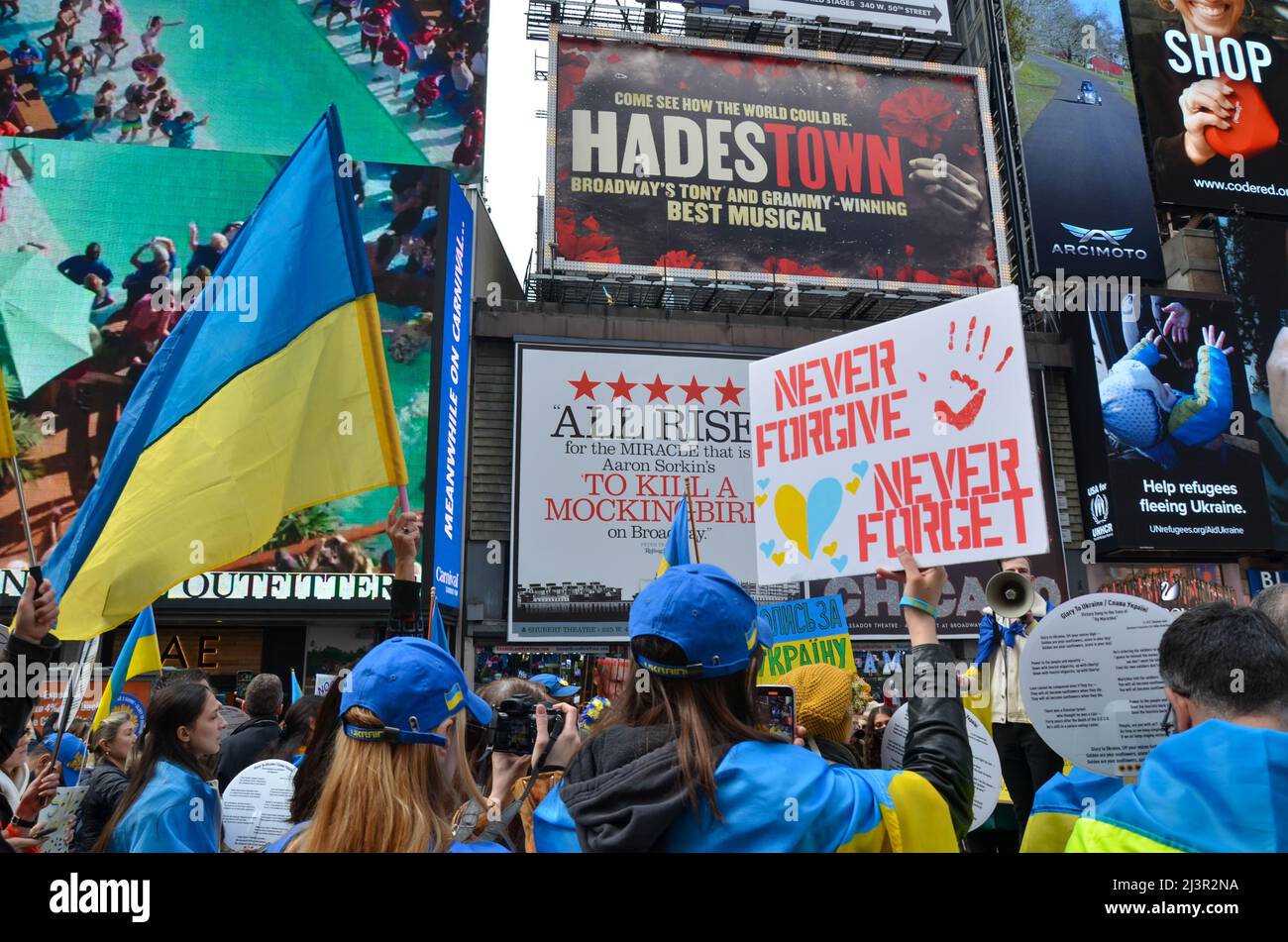 Die Teilnehmer halten am 09. April 2022 am Times Square in New York City eine ukrainische Flagge, um ihre Unterstützung für die Ukraine zu zeigen. Stockfoto