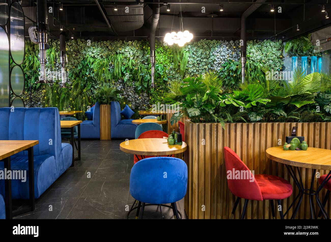 Moskau - 17. Dez 2021: Vertikaler Garten im Restaurantinnenraum, Landschaftsgestaltung im modernen Café, gemütliches Öko-Design im Innenbereich. Wand mit natürlichen grünen Pflanzen, Stockfoto