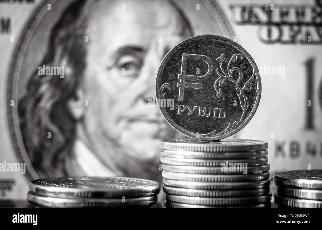 Das Geld Russlands und der USA in schwarz-weiß, russische Rubel-Münze auf dem Hintergrund des US-Dollar-Scheines. Konzept der Wirtschaftskrise, Rubelgaszahlung, Finanzen, Stockfoto